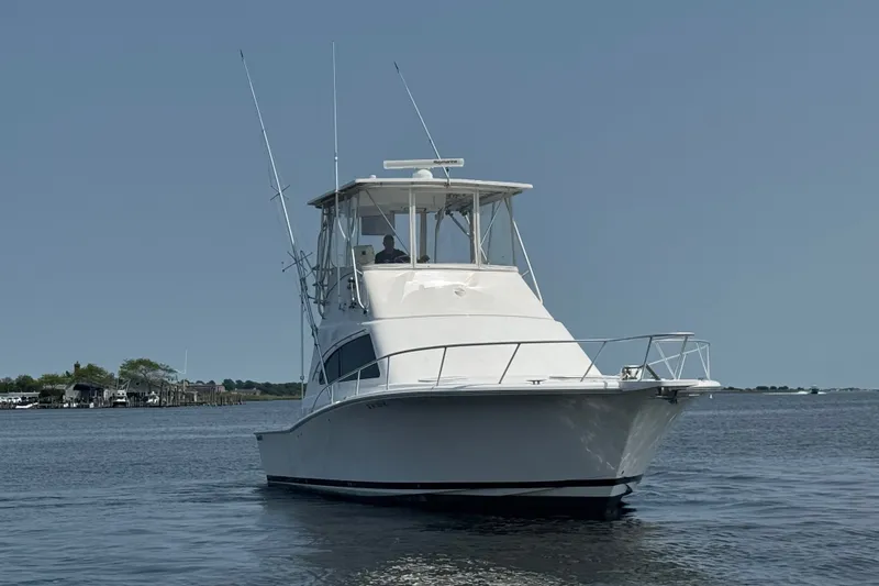 Slide: The Image of 2004 Luhrs 38 Convertible boat cruising on calm waters under clear sky. - 45