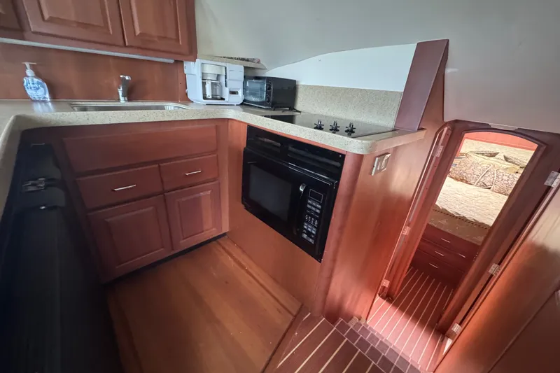 Slide: The Image of 2004 Luhrs 38 Convertible yacht kitchen with wood cabinetry and modern appliances. - 23