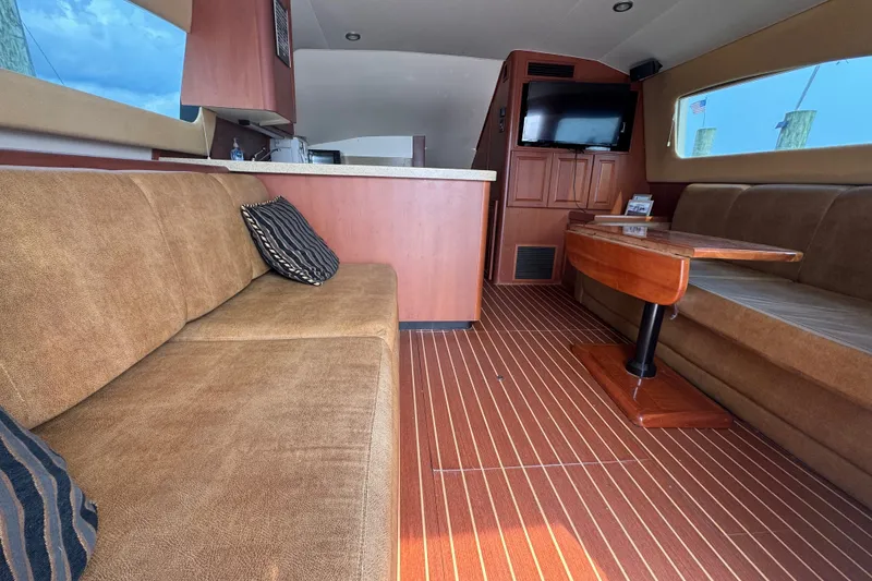 Slide: The Image of Interior of 2004 Luhrs 38 Convertible yacht with cozy seating and wooden accents. - 18