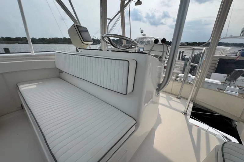 Slide: The Image of 2004 Luhrs 38 Convertible boat interior with white seating and steering wheel. - 37