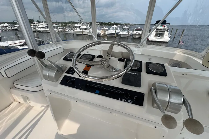 Slide: The Image of 2004 Luhrs 38 Convertible yacht helm with steering wheel and controls, docked at marina. - 35
