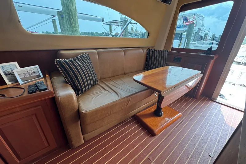 Slide: The Image of Interior of 2004 Luhrs 38 Convertible yacht with sofa, table, and striped cushions. - 22