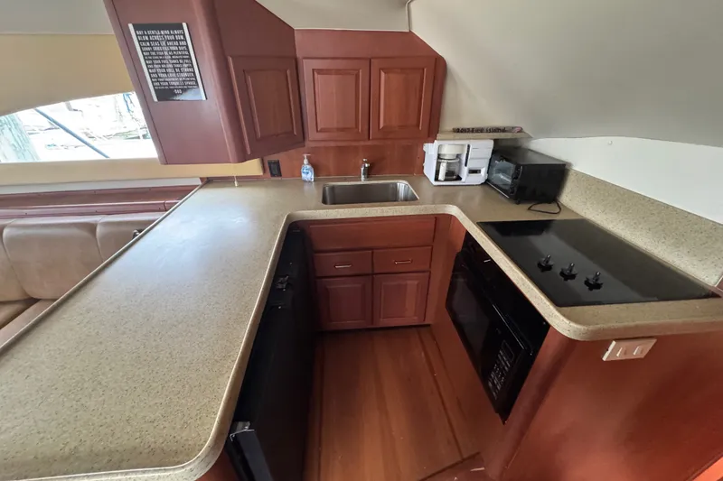 Slide: The Image of 2004 Luhrs 38 Convertible yacht kitchen with modern appliances and wooden cabinetry. - 25