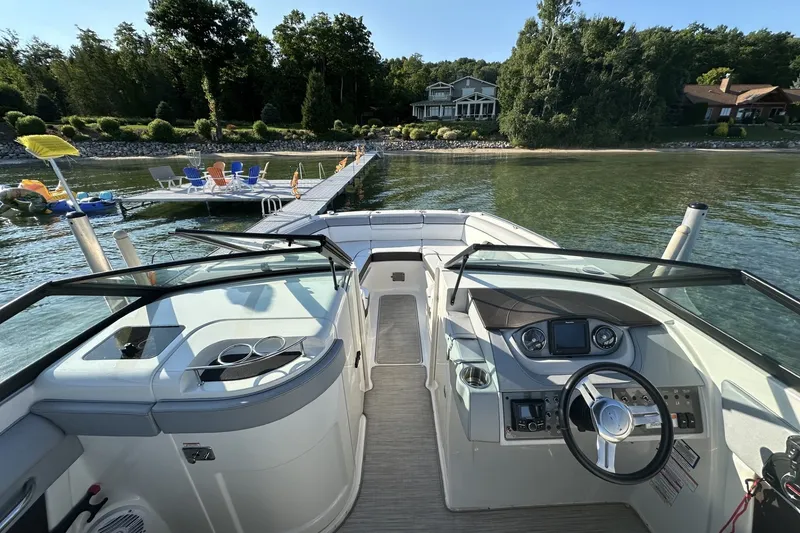 Slide: The Image of 2017 Sea Ray SDX 270 boat docked by a scenic lakeside with lush greenery. - 4