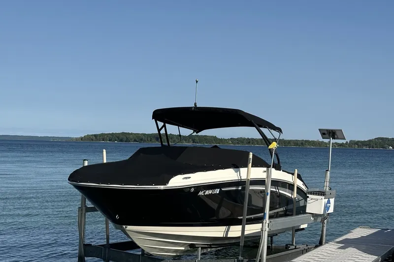 Slide: The Image of 2017 Sea Ray SDX 270 boat docked by a serene lake under clear blue skies. - 0