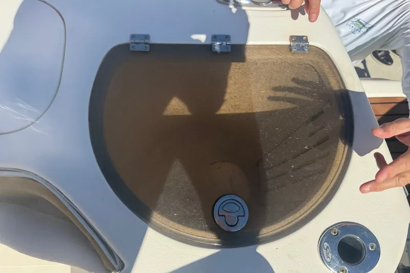 Slide: The Image of Livewell on 2008 Scout 282 Sportfish boat with hands and shadow visible. - 16