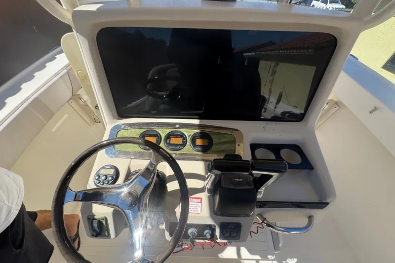 Slide: The Image of 2008 Scout 282 Sportfish boat dashboard with steering wheel and controls. - 55