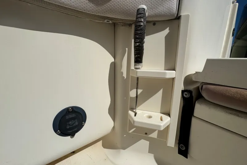 Slide: The Image of 2008 Scout 282 Sportfish boat interior detail with fishing rod holder and utility compartment. - 62