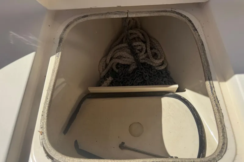 Slide: The Image of Anchor storage compartment on a 2008 Scout 282 Sportfish boat, featuring rope and chain. - 25