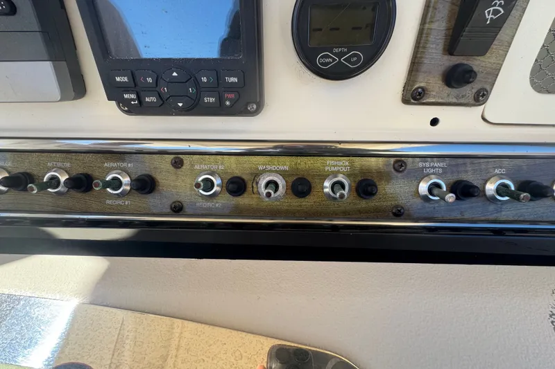 Slide: The Image of Control panel of a 2008 Scout 282 Sportfish boat with various switches and gauges. - 47