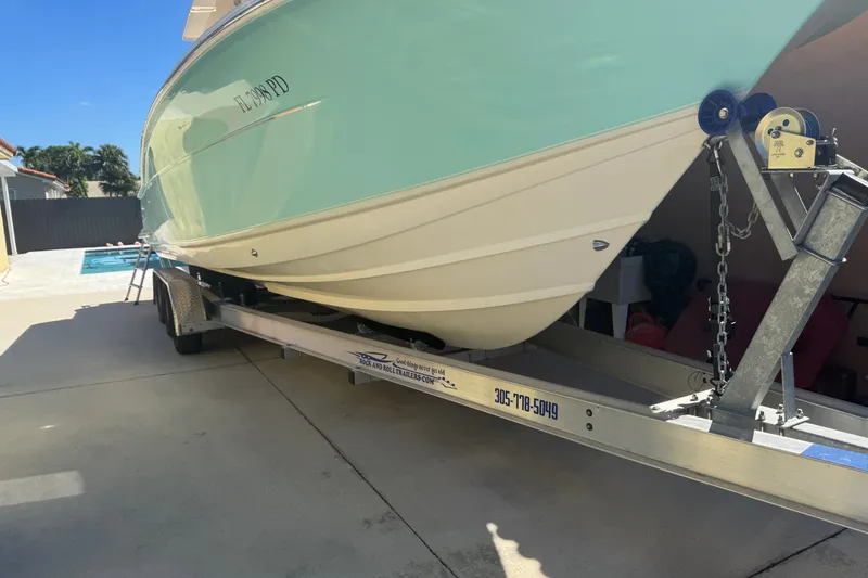 Slide: The Image of 2008 Scout 282 Sportfish boat on trailer in driveway, sunny day. - 3