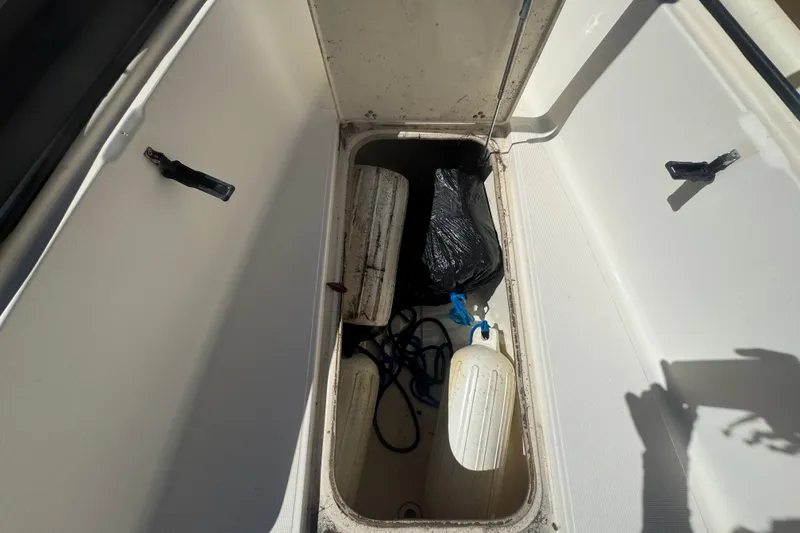 Slide: The Image of Open storage compartment on 2008 Scout 282 Sportfish boat with various items inside. - 28