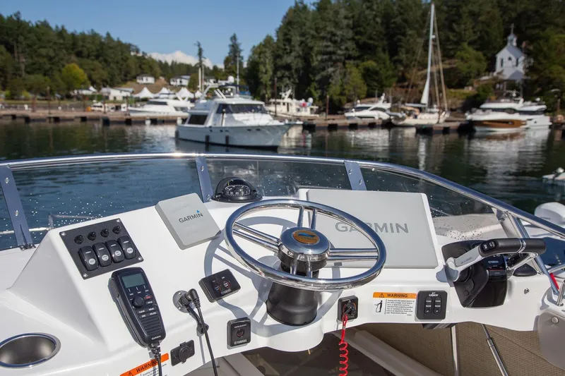 Slide: The Image of Helm of 2027 Cutwater C-32 CB boat with Garmin navigation, docked in scenic marina. - 14
