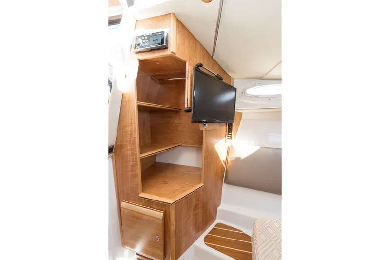 Slide: The Image of 2027 Cutwater C-32 CB cabin interior with wooden shelves and mounted TV. - 28