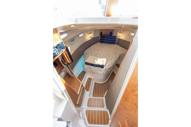 Slide: The Image of 2027 Cutwater C-32 CB cabin interior with cozy bed and elegant wood finishes. - 26