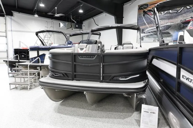 Slide: The Image of 2026 Evotti 721QL pontoon boat displayed in a showroom with sleek design. - 2