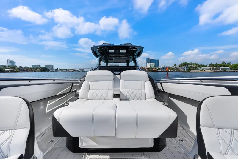 Slide: The Image of 2024 Nor-Tech 450 Sport boat interior with luxurious white seating on a sunny day. - 39