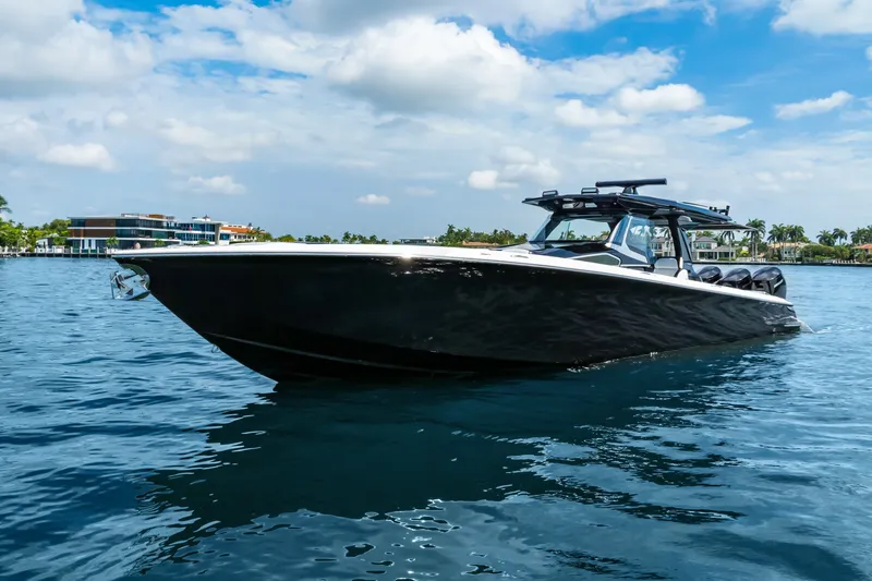 Slide: The Image of 2024 Nor-Tech 450 Sport boat cruising on a sunny day, with modern buildings in the background. - 1