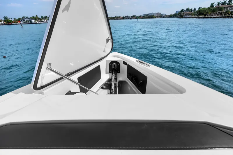 Slide: The Image of 2024 Nor-Tech 450 Sport boat with open storage compartment on calm water. - 43