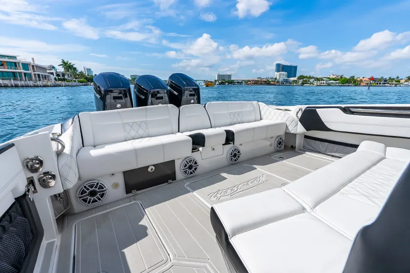 Slide: The Image of 2024 Nor-Tech 450 Sport boat interior with luxurious seating and powerful engines on a sunny day. - 54