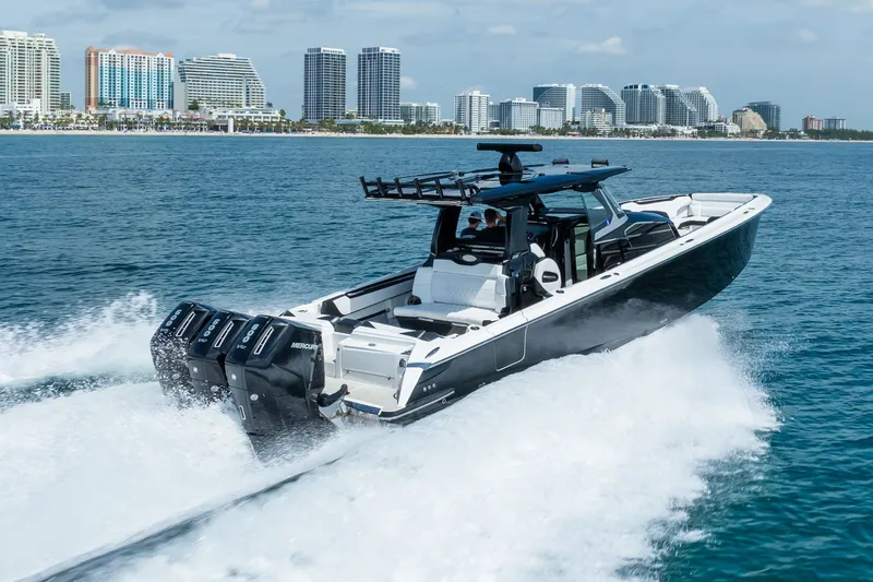 Slide: The Image of 2024 Nor-Tech 450 Sport boat cruising on ocean near city skyline. - 12