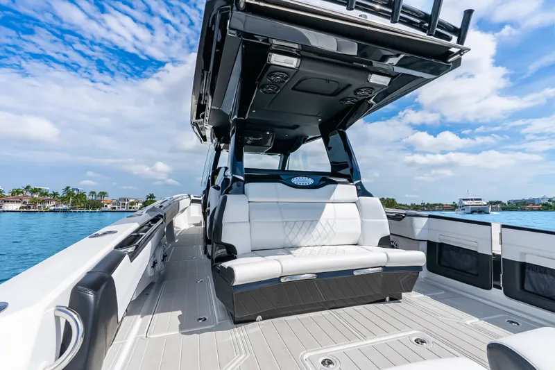 Slide: The Image of 2024 Nor-Tech 450 Sport boat interior with luxurious seating on a sunny day. - 58