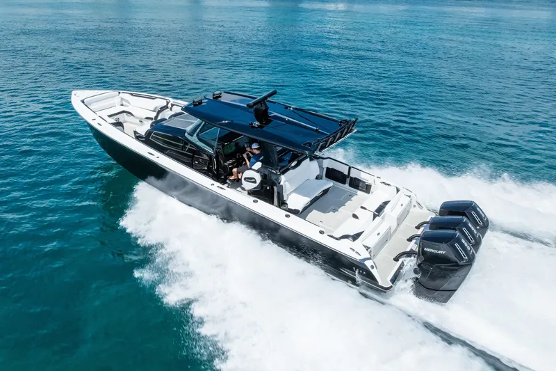 Slide: The Image of 2024 Nor-Tech 450 Sport boat cruising on clear blue water, showcasing powerful engines. - 24