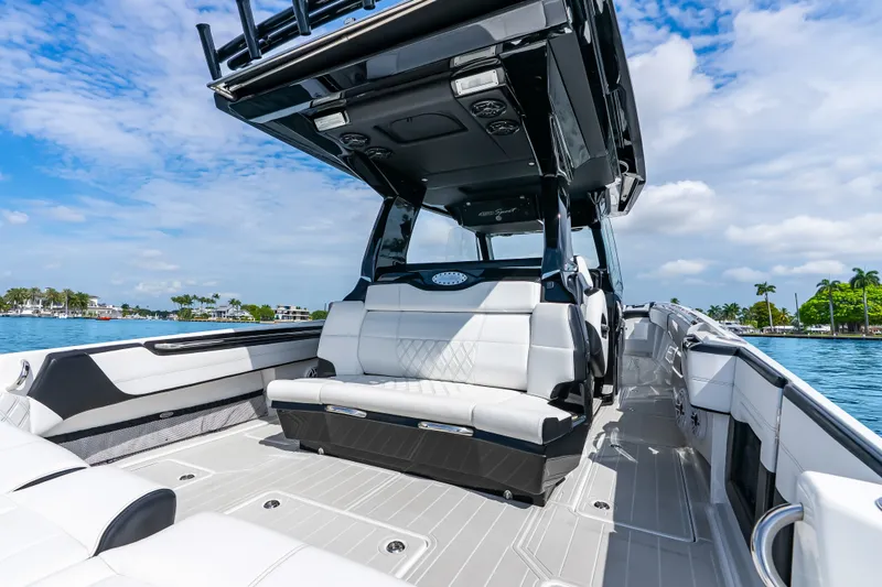 Slide: The Image of 2024 Nor-Tech 450 Sport boat interior with luxurious seating and sleek design on a sunny day. - 57