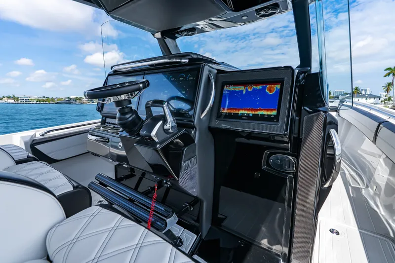 Slide: The Image of 2024 Nor-Tech 450 Sport boat cockpit with advanced navigation display and luxurious seating. - 63