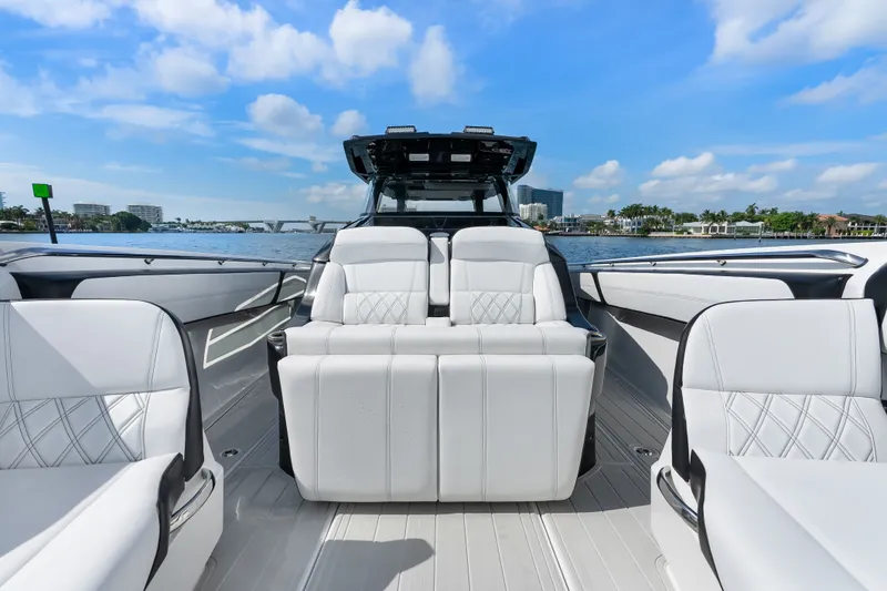 Slide: The Image of 2024 Nor-Tech 450 Sport boat interior with luxurious white seating on a sunny day. - 40