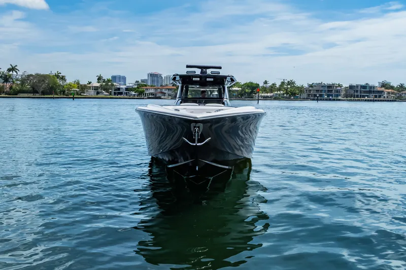 Slide: The Image of 2024 Nor-Tech 450 Sport boat on calm water, with cityscape background. - 8