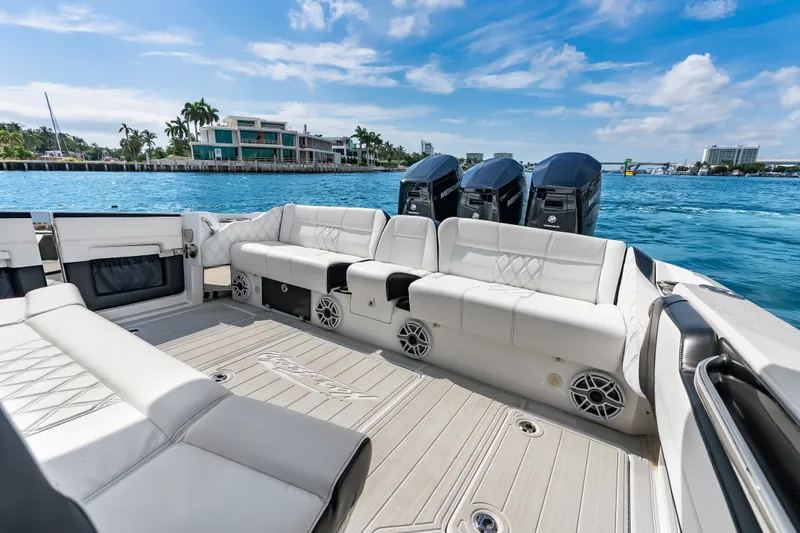 Slide: The Image of 2024 Nor-Tech 450 Sport boat interior with luxurious seating and powerful engines on a sunny day. - 50