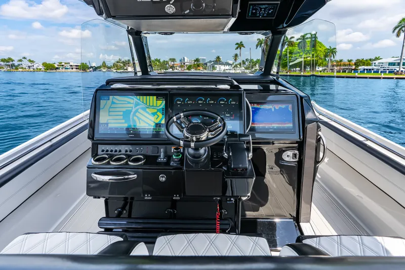 Slide: The Image of 2024 Nor-Tech 450 Sport boat cockpit with advanced navigation displays and luxurious seating. - 62
