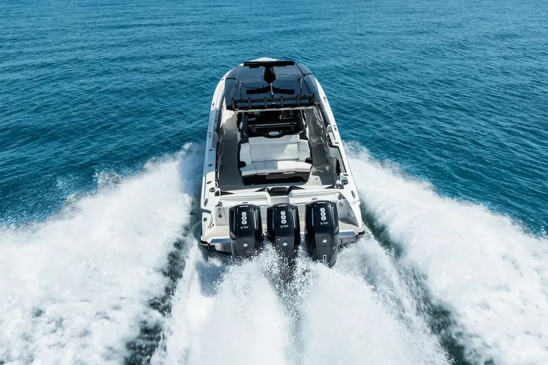 Slide: The Image of 2024 Nor-Tech 450 Sport boat cruising on open water, rear view. - 11