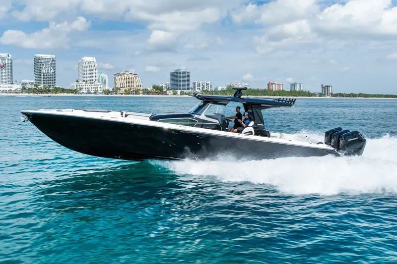 Slide: The Image of 2024 Nor-Tech 450 Sport boat cruising on blue water near city skyline. - 22