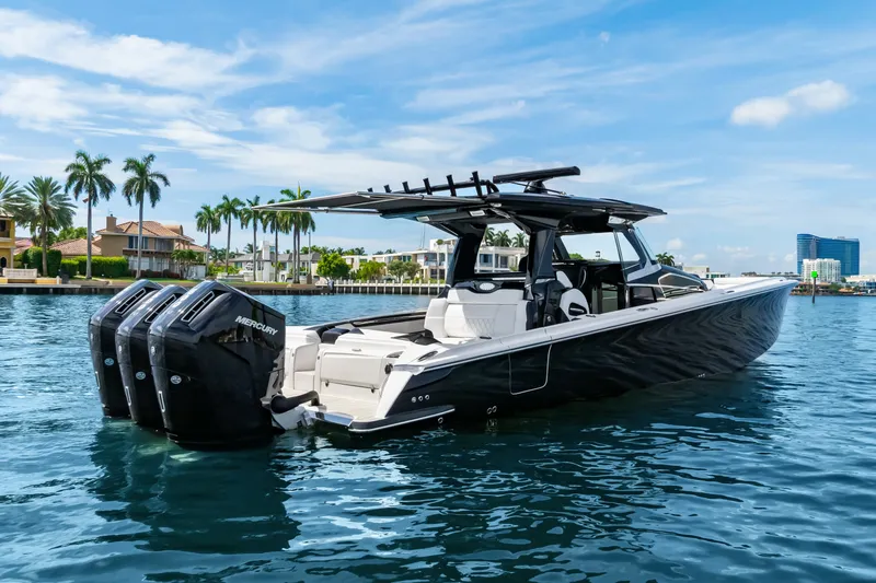 Slide: The Image of 2024 Nor-Tech 450 Sport boat with triple Mercury engines on a sunny waterfront. - 3