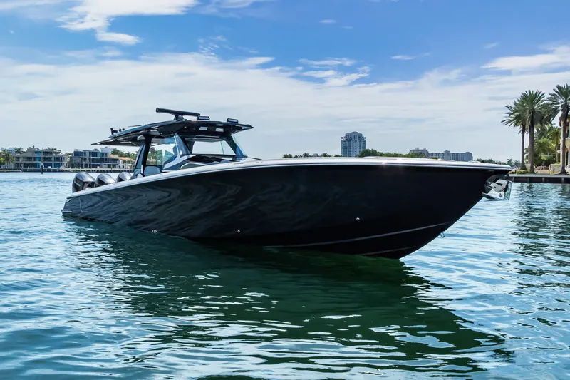 Slide: The Image of 2024 Nor-Tech 450 Sport boat on calm water, with a sleek black design. - 9