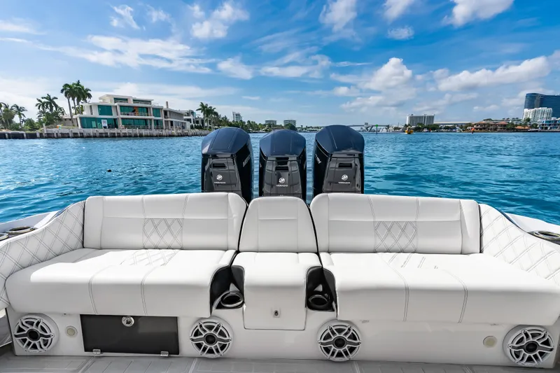 Slide: The Image of 2024 Nor-Tech 450 Sport boat with luxurious seating and powerful engines on a sunny day. - 53