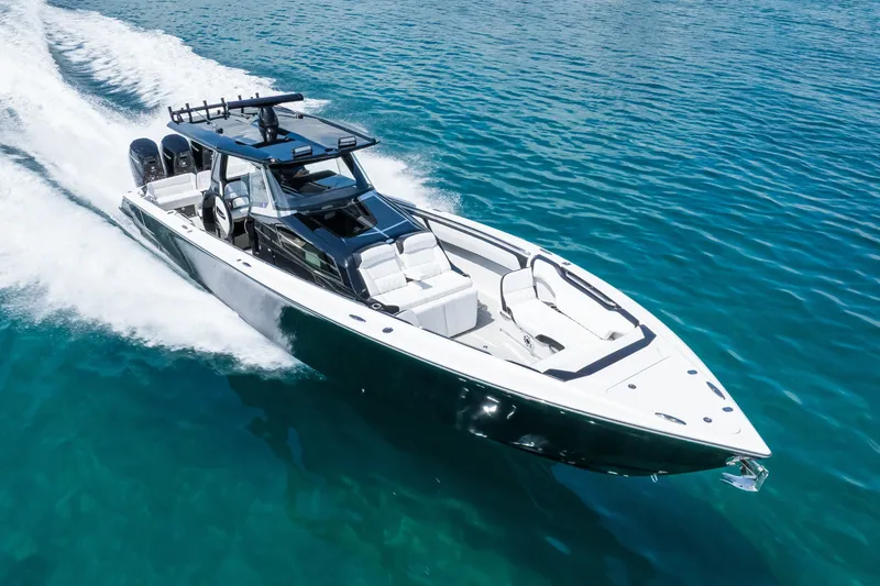Slide: The Image of 2024 Nor-Tech 450 Sport boat cruising on clear blue water. - 16