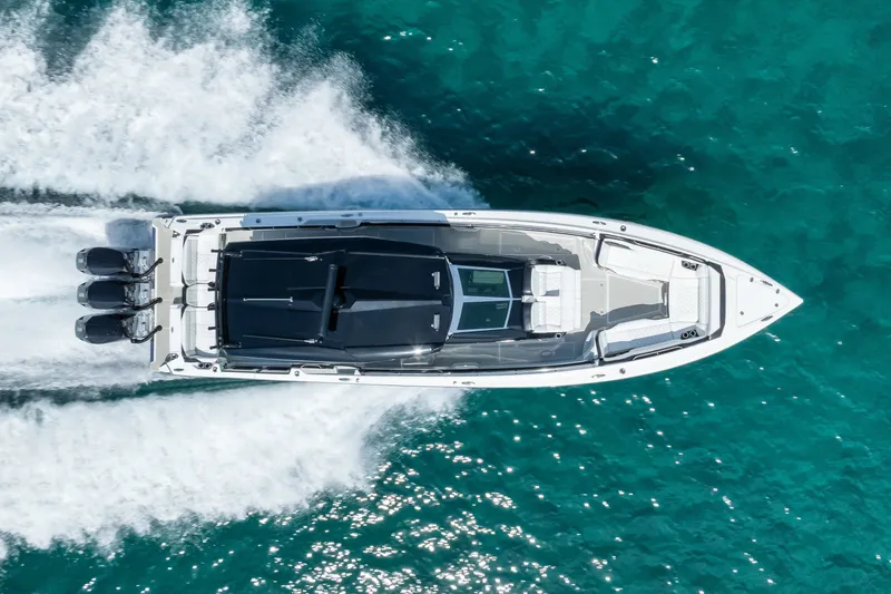 Slide: The Image of Aerial view of 2024 Nor-Tech 450 Sport boat cruising on turquoise water. - 17