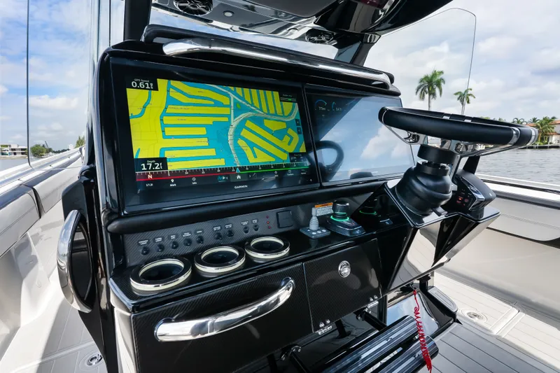 Slide: The Image of 2024 Nor-Tech 450 Sport boat dashboard with GPS navigation system and steering wheel. - 67