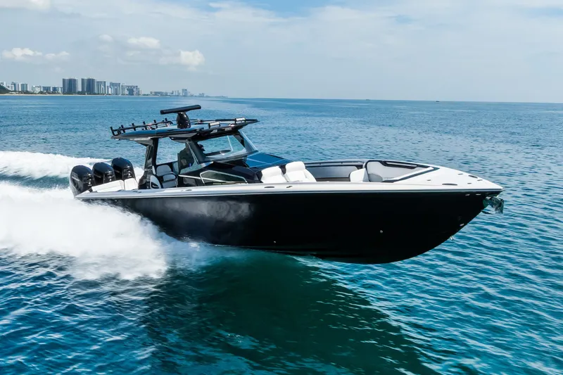 Slide: The Image of 2024 Nor-Tech 450 Sport boat cruising on open water, city skyline in background. - 20