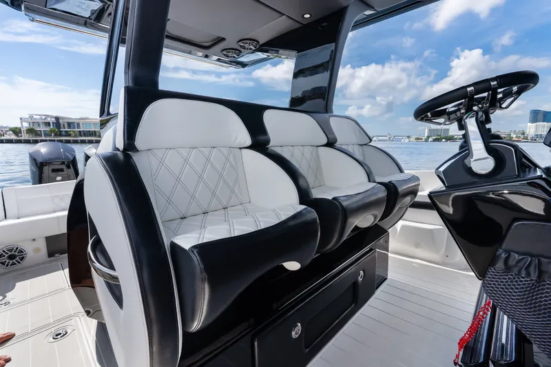 Slide: The Image of 2024 Nor-Tech 450 Sport boat interior with luxurious seating and modern steering console. - 66