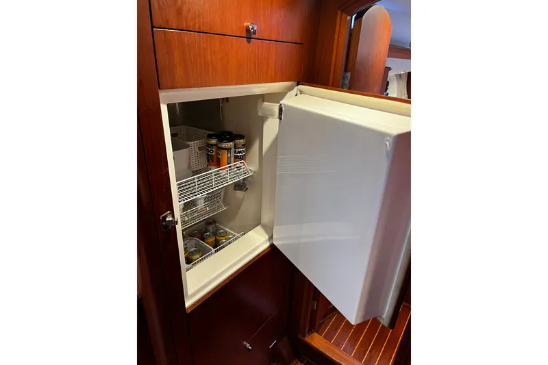 Slide: The Image of Open fridge in 1999 Oyster 53 Deck Saloon yacht, stocked with beverages and organized shelves. - 46