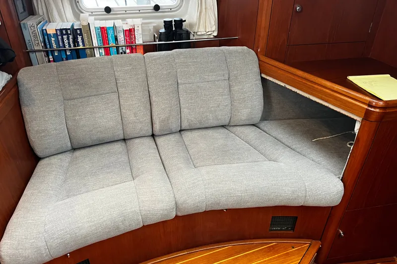 Slide: The Image of Cozy seating area in 1999 Oyster 53 Deck Saloon with books and wooden cabinetry. - 17