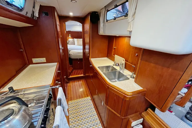 Slide: The Image of Luxurious interior of a 1999 Oyster 53 Deck Saloon yacht with wood finishes and modern amenities. - 22