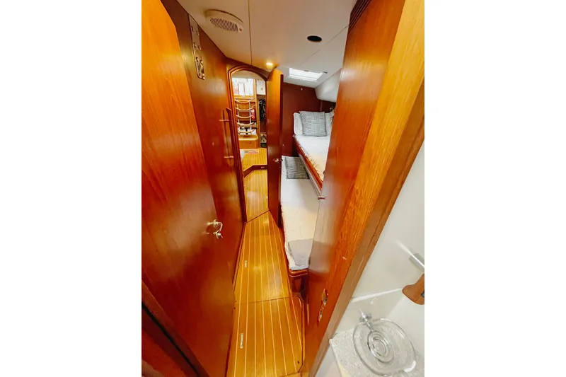 Slide: The Image of Interior of 1999 Oyster 53 Deck Saloon yacht with wooden paneling and cozy bunk beds. - 7