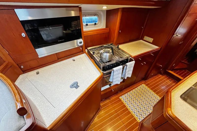 Slide: The Image of Luxurious 1999 Oyster 53 Deck Saloon yacht kitchen with modern appliances and wooden cabinetry. - 23
