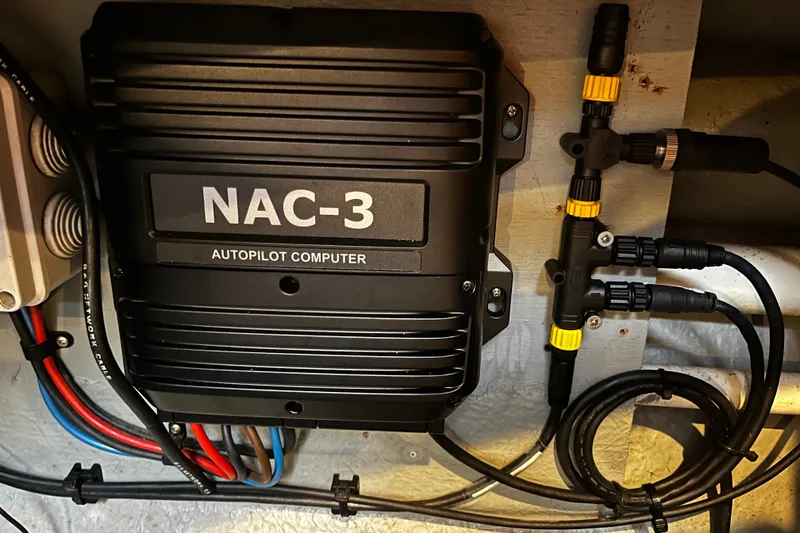 Slide: The Image of NAC-3 autopilot computer in 1999 Oyster 53 Deck Saloon, with connected cables and components. - 52
