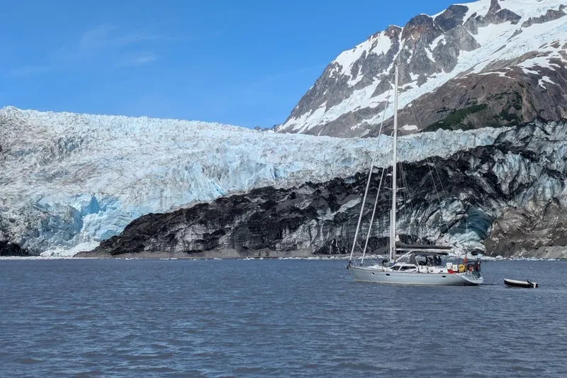 Slide: The Image of Sailboat Oyster 53 Deck Saloon (1999) near a glacier with snowy mountains in the background. - 84